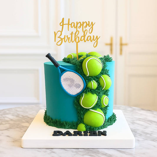 Birthday cake with tennis ball and racket decorations on a marble surface.
