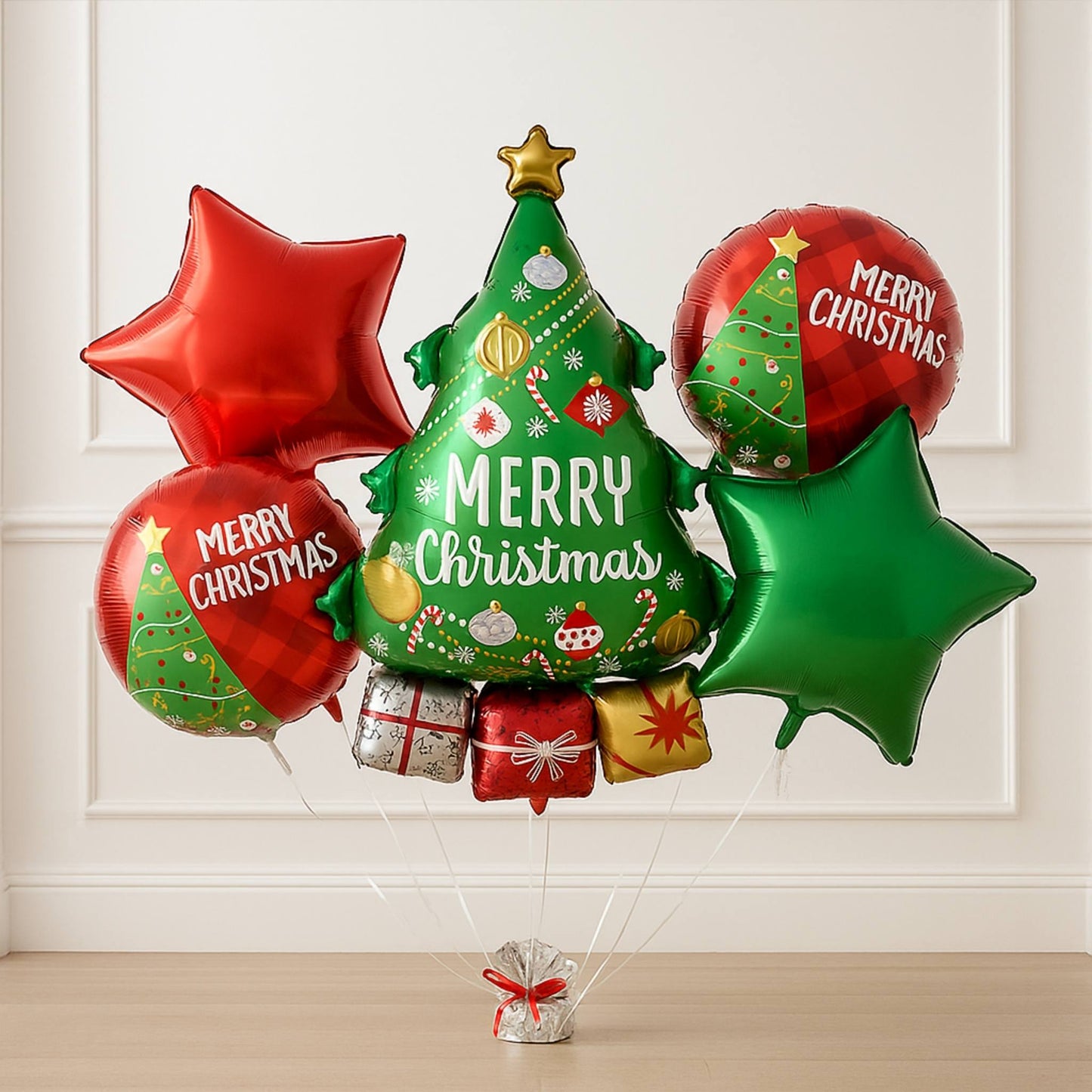 Christmas-themed balloons with 'Merry Christmas' text and festive designs on a white paneled wall background.