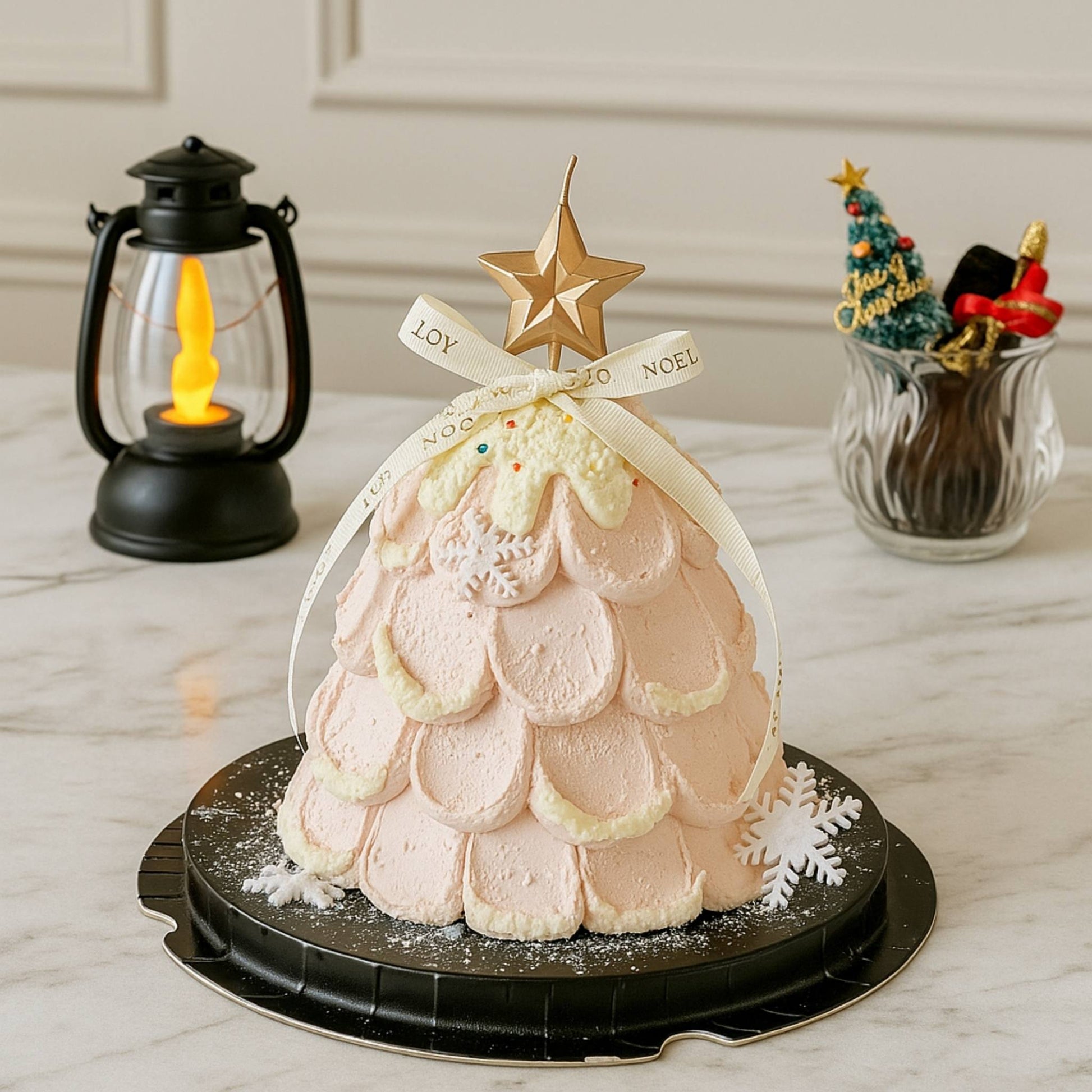 Decorative cake shaped like a Christmas tree with a star on top, placed on a marble surface.