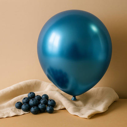 Blue chrome 11 inch helium balloon and blueberries on a beige cloth against a beige background