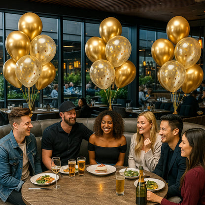 Group of people celebrating with gold balloons and drinks in a restaurant.