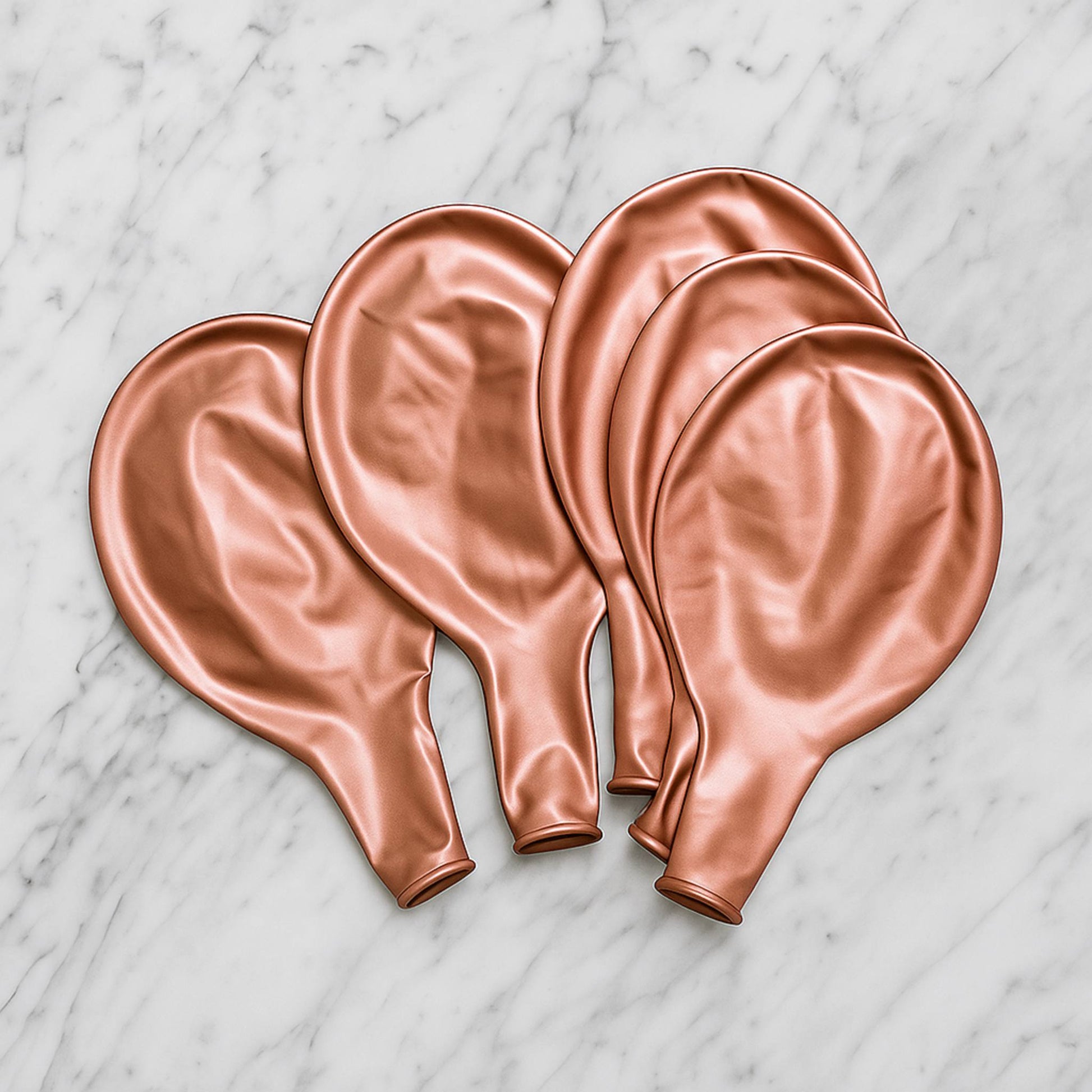Set of rose gold balloons on a marble surface
