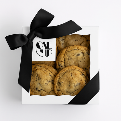 A gift box of freshly baked cookies with a corporate logo, tied with a black ribbon.