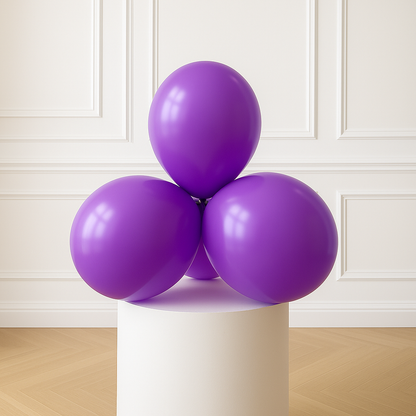 Purple balloons on a white pedestal against a white paneled wall.