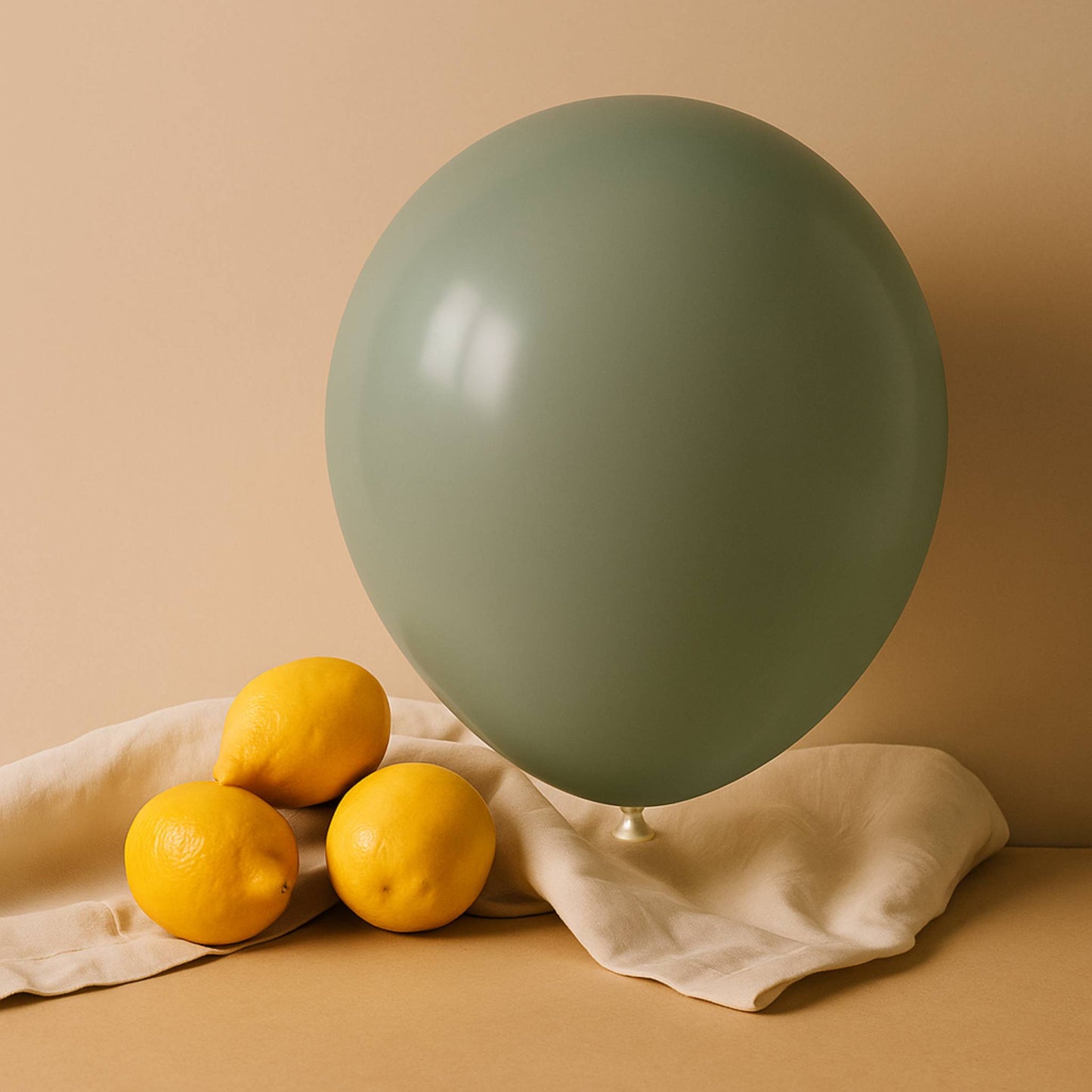 Green balloon and lemons on a beige surface with a beige background