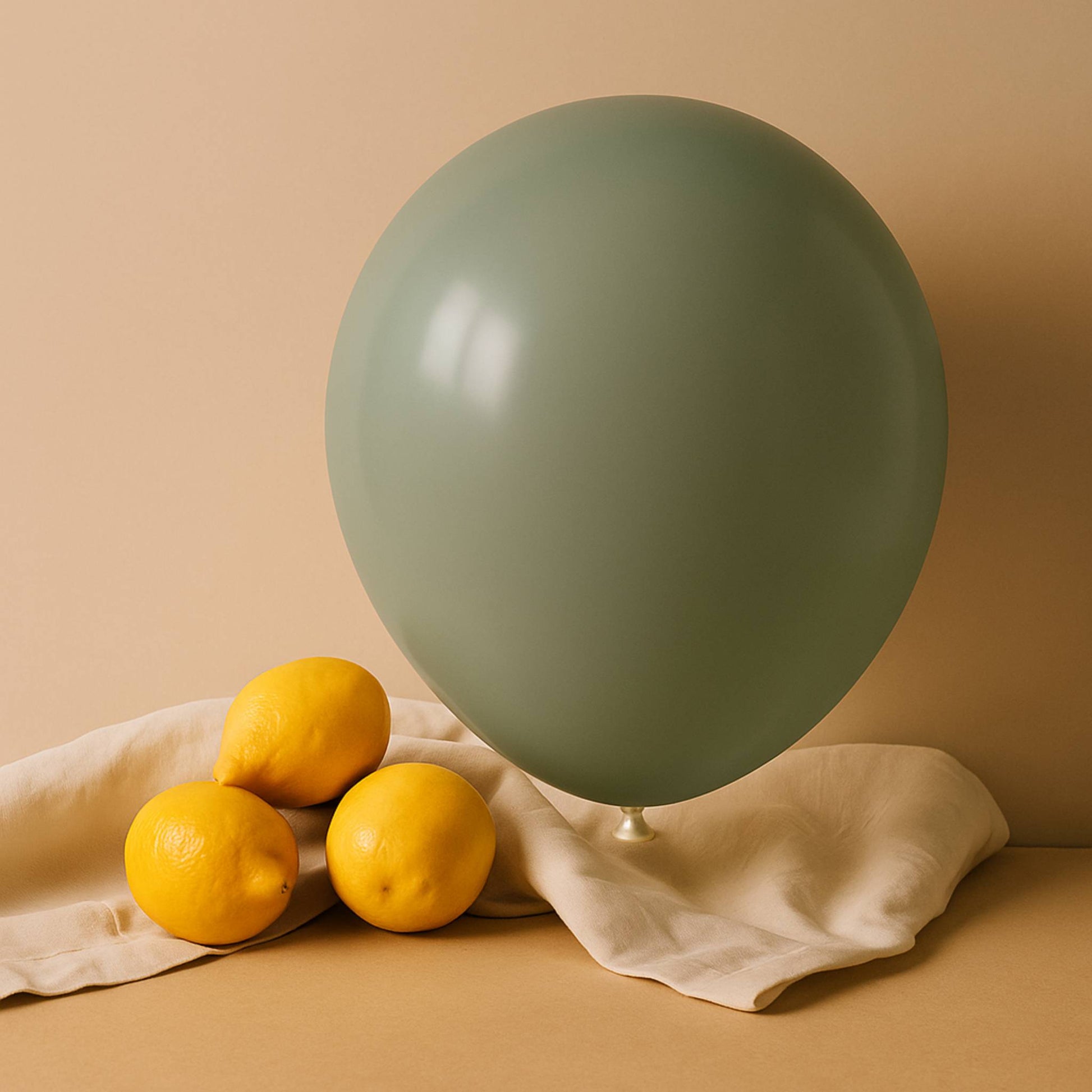 Green balloon and lemons on a beige surface with a beige background