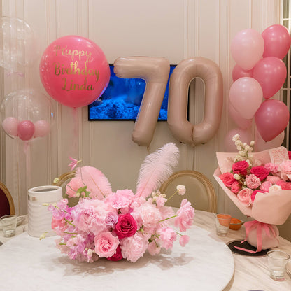 Decorated birthday table with balloons, flowers, and 'Happy Birthday Linda' sign.
