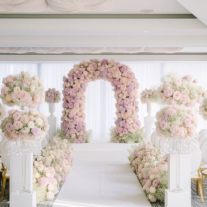 Decorative floral archway with pink and white flowers at a wedding ceremony.