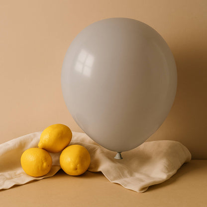 White balloon and lemons on a beige cloth against a beige background