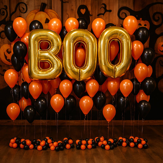 Halloween-themed balloon setup with 'BOO' balloons and orange, black, and red balloons against a wooden background.