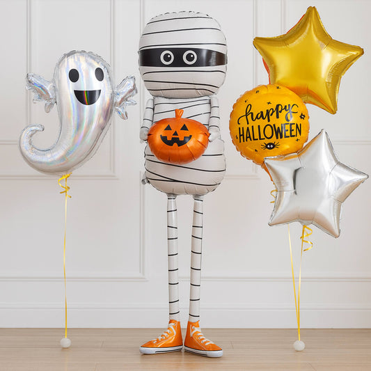 Halloween-themed balloons including a ghost, mummy, and pumpkins on a wooden floor.
