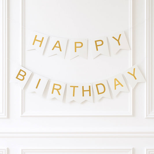 White and gold 'Happy Birthday' banner on a white wall.