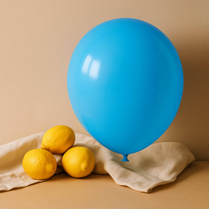 Blue 11 inch helium balloon and lemons on a beige surface with a beige background