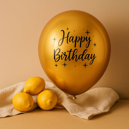Gold balloon with 'Happy Birthday' text next to lemons on a beige background
