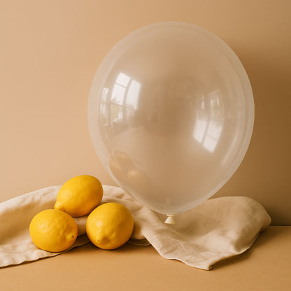 White clear balloon and lemons on a beige surface with a beige background