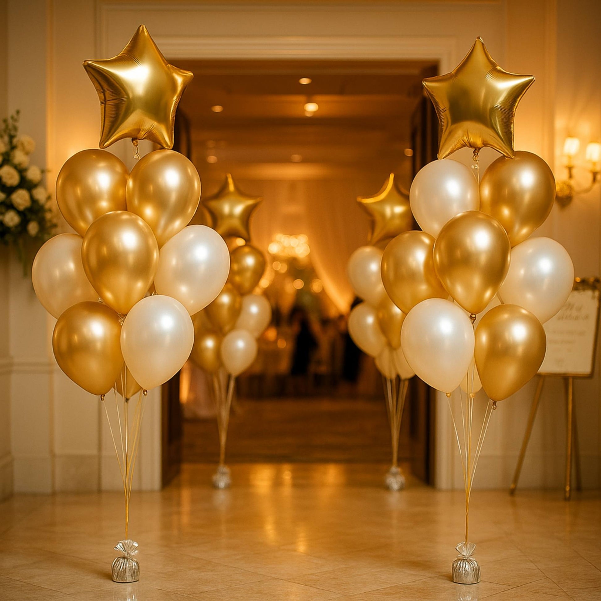Gold and white balloons with star-shaped balloons in a formal event setting.