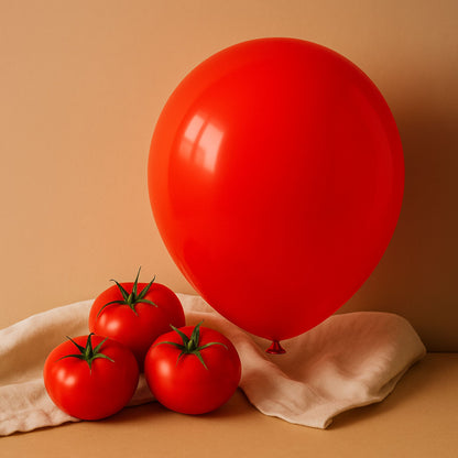 Red balloon and tomatoes on a beige surface with a beige background