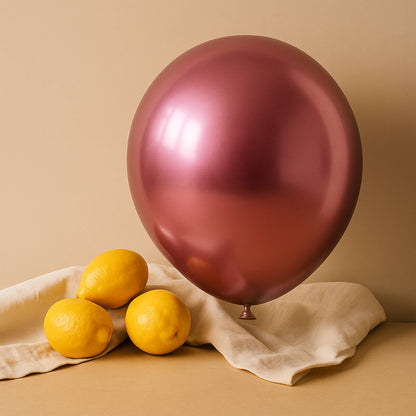 Pink 11 inch helium balloon and lemons on a beige surface with a beige background
