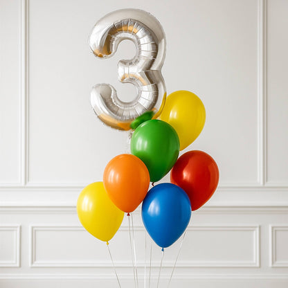 Silver number 3 balloon with colorful balloons against a white paneled wall