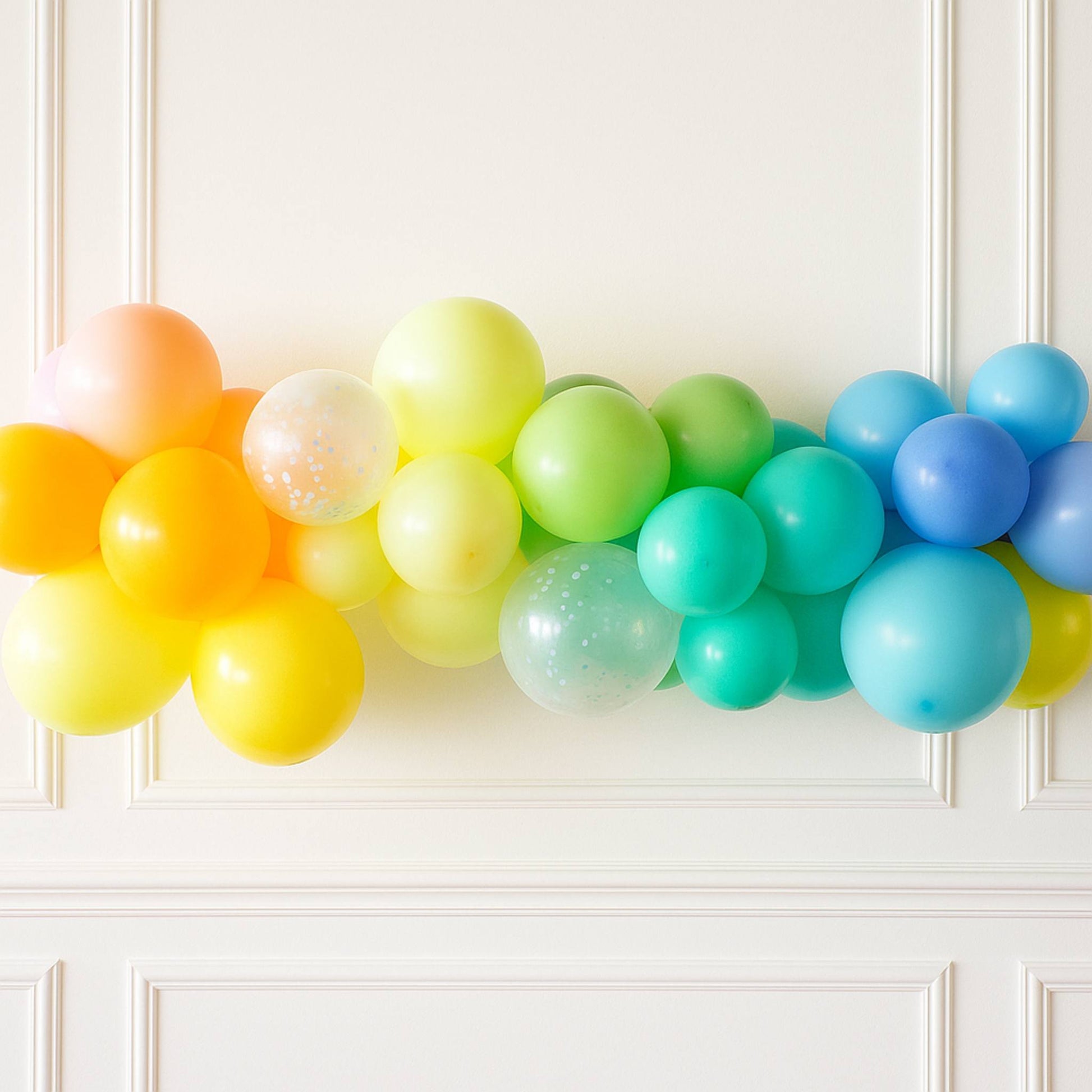 Colorful balloon arch against a white wall