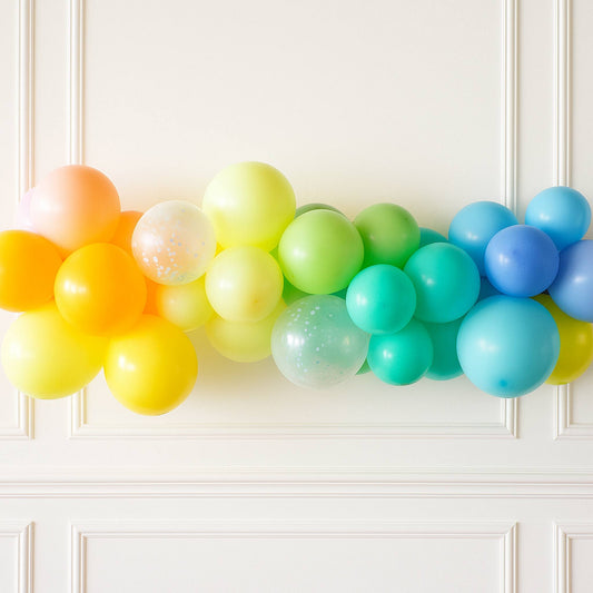 Colorful balloon arch against a white wall