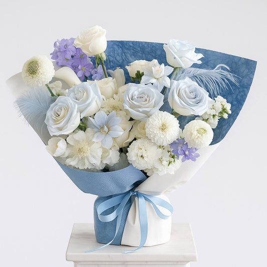 Bouquet of white and light blue flowers with a blue ribbon on a white background