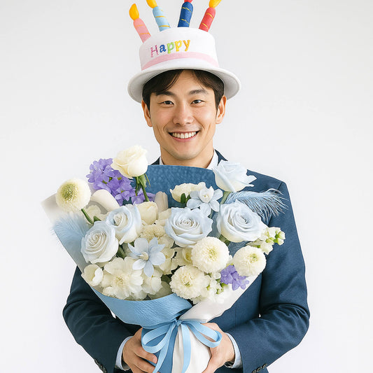 Man wearing a 'Happy' birthday hat holding a bouquet of flowers on a white background