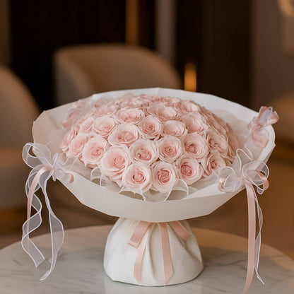 Bouquet of pink roses on a white pedestal with ribbons against a blurred background