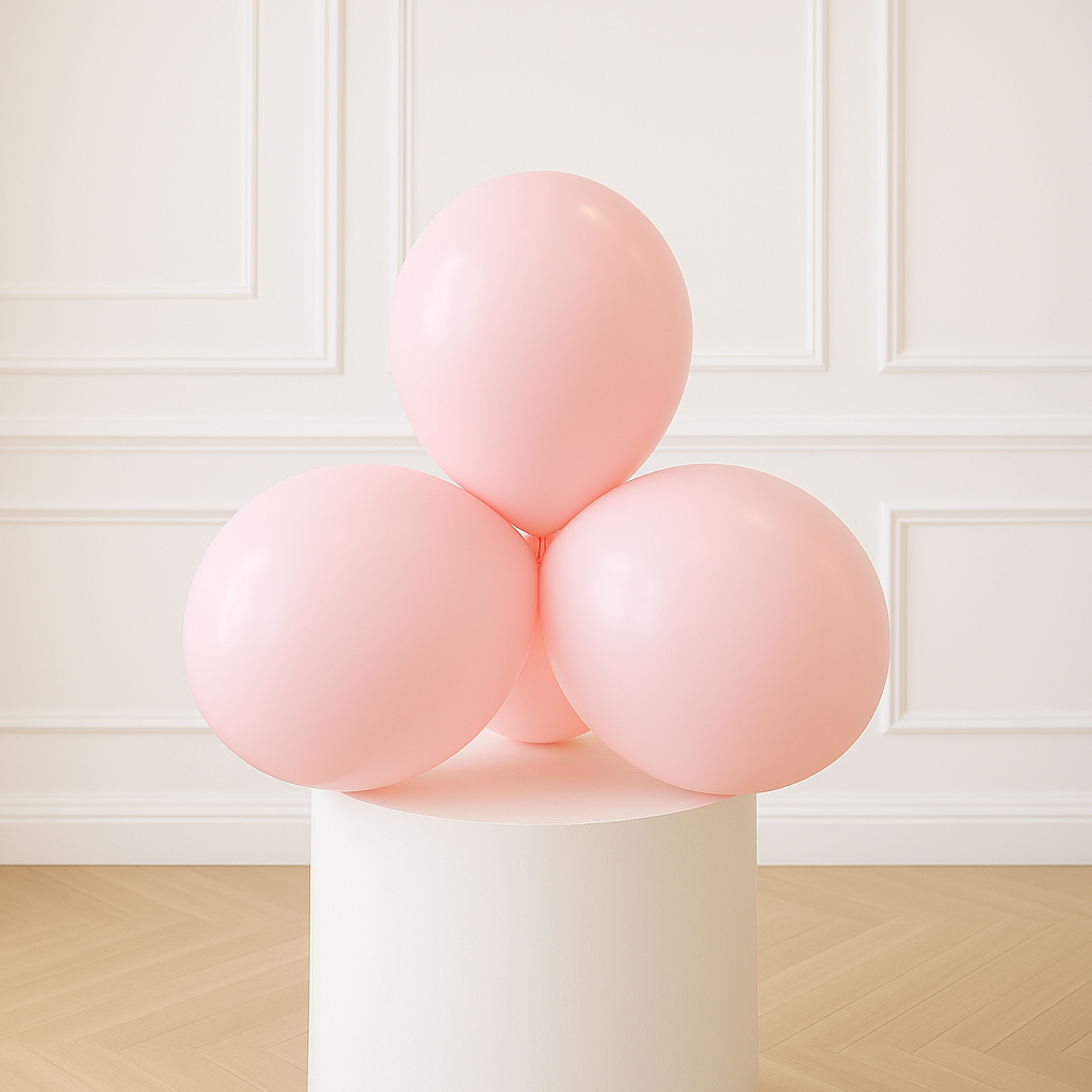 Pastel Pink balloons on a white pedestal against a white paneled wall.