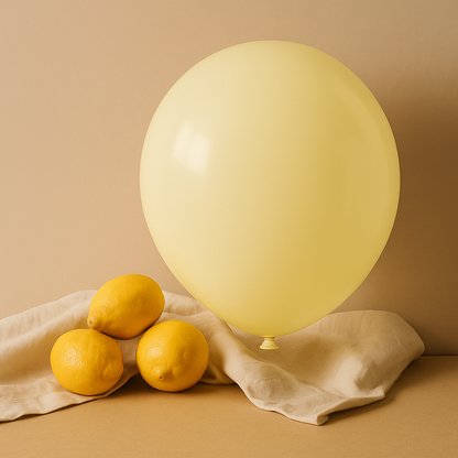 Yellow balloon and lemons on a beige cloth against a beige background