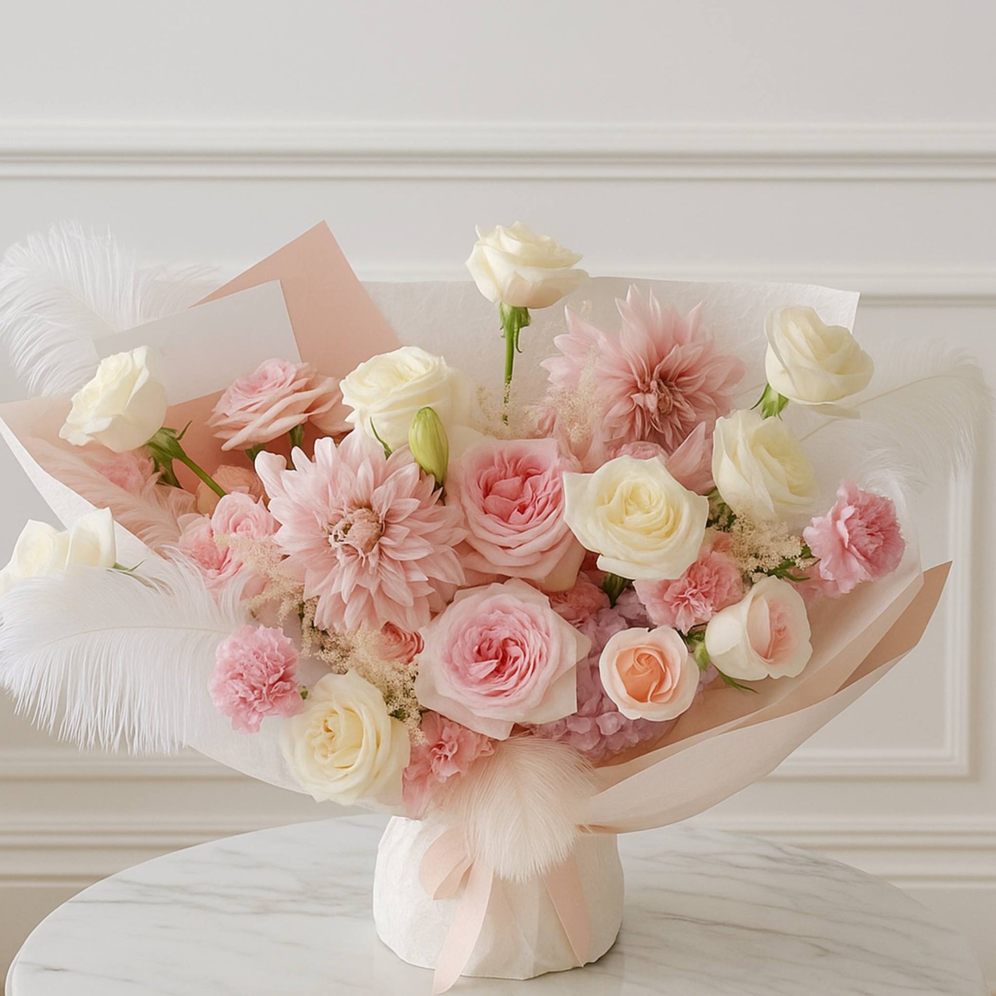 Bouquet of pink and white flowers on a white surface with a light-colored wall background
