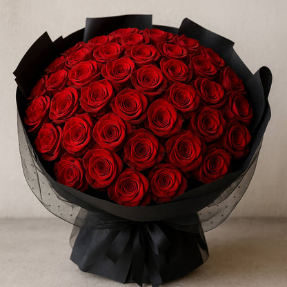 Bouquet of red roses wrapped in black paper on a neutral background