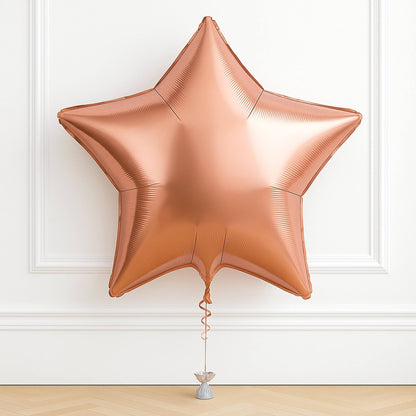 Rose gold star-shaped balloon on a white wall background
