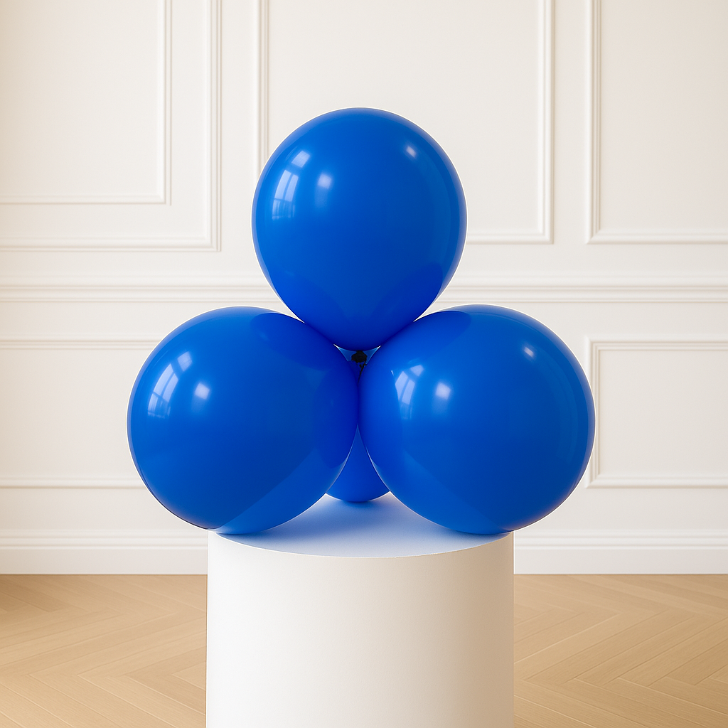 Four blue balloons on a white pedestal against a white paneled wall.