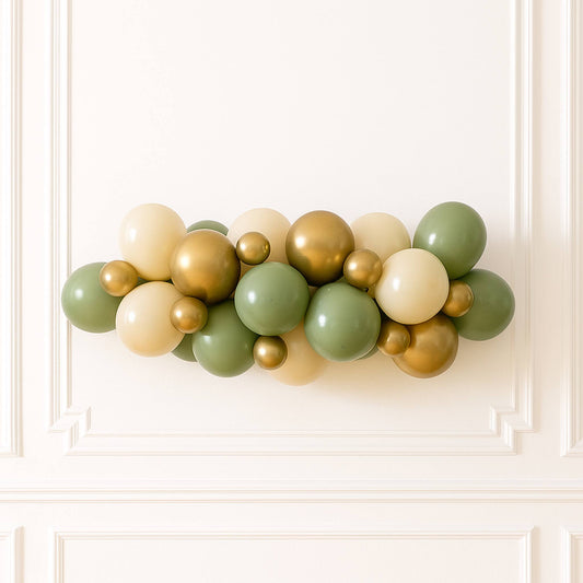 Balloon garland in gold, green, and beige on a white wall