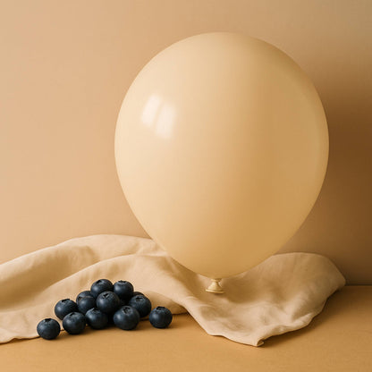 Beige 11 inch helium balloon and blueberries on a beige surface with a beige background