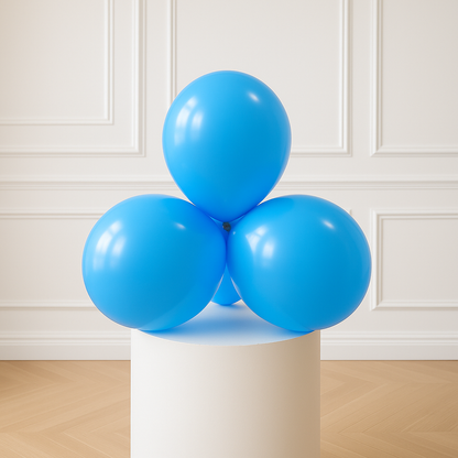 Three sky blue balloons on a white cylindrical stand against a white paneled wall.