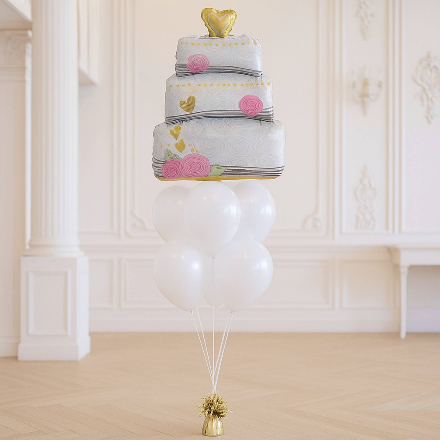 Balloon sculpture of a multi-layered cake with decorative elements on a white background