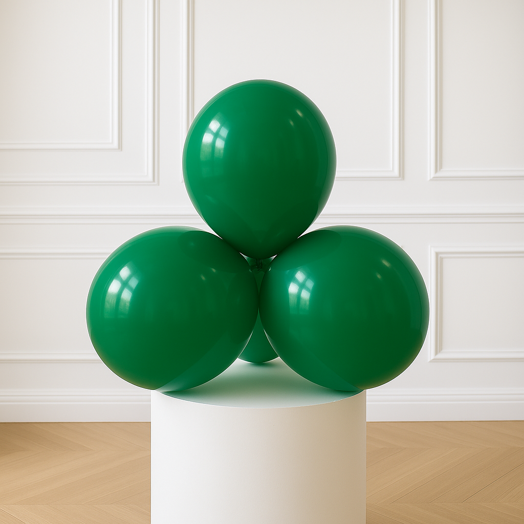 Three green balloons on a white pedestal against a white paneled wall.
