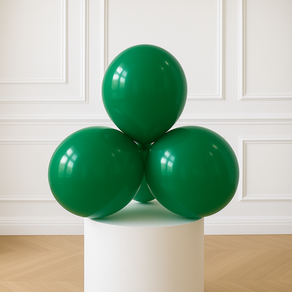 Three green balloons on a white pedestal against a white paneled wall.
