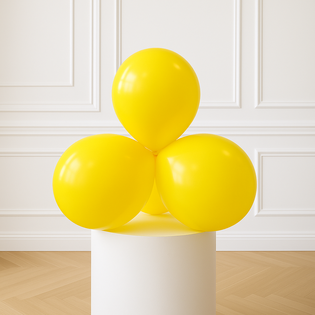 Three yellow balloons on a white cylindrical stand against a white paneled wall.