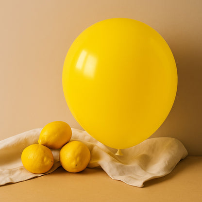 Yellow balloon and lemons on a beige surface with a beige background