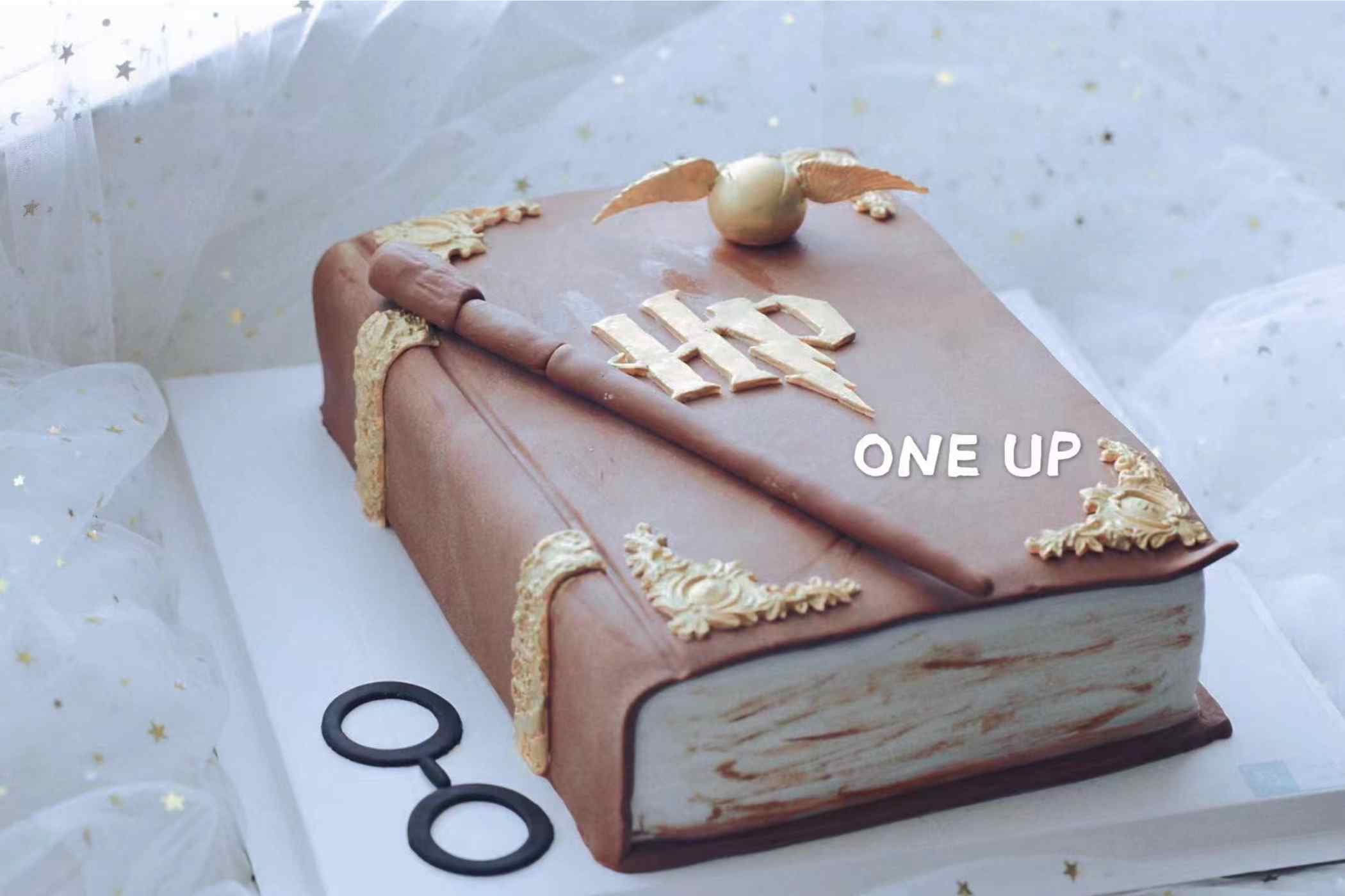 Cake designed to look like a book with decorative elements on a white background