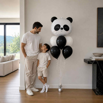 Man and child standing next to a panda-shaped balloon in a modern living room.
