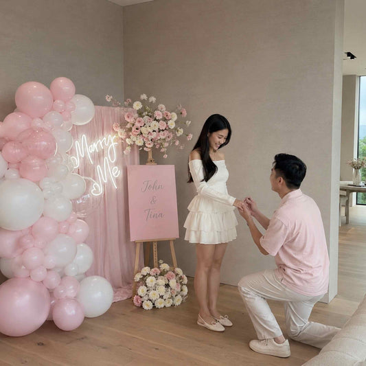 Man proposing to a woman in a decorated room with balloons and flowers.