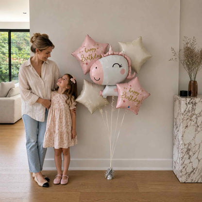 Woman and child with birthday balloons in a living room