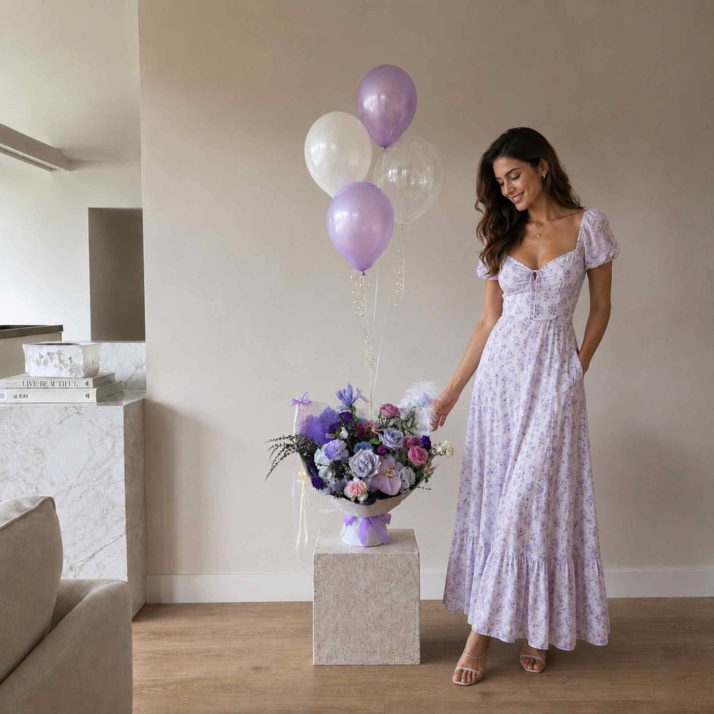 Woman in a floral dress holding a bouquet of flowers and balloons in a room.