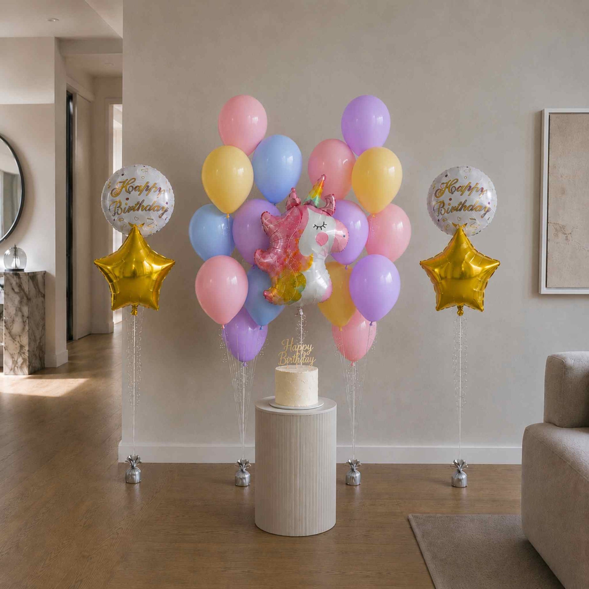 Colorful balloon arrangement with a unicorn and stars on a pedestal in a living room.
