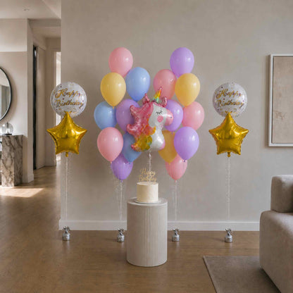 Colorful balloon arrangement with a unicorn and stars on a pedestal in a living room.