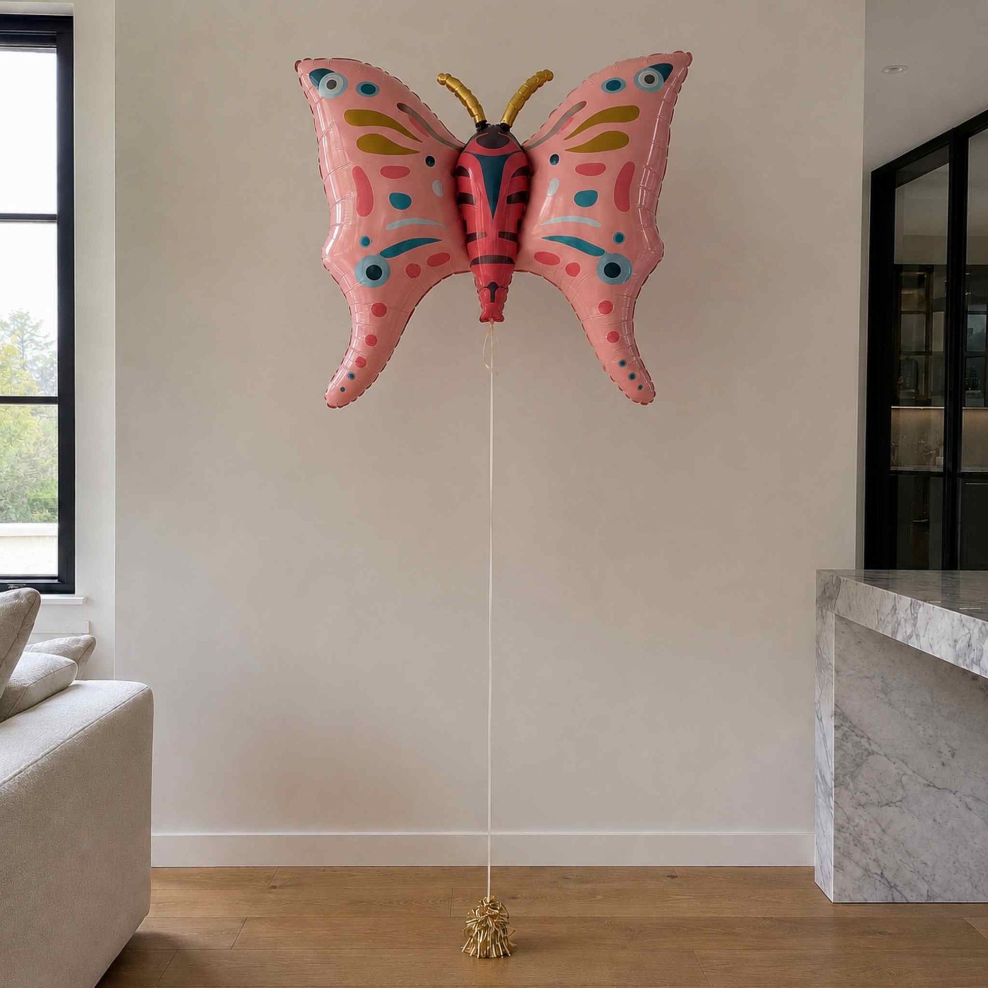 Pink butterfly-shaped balloon in a living room setting